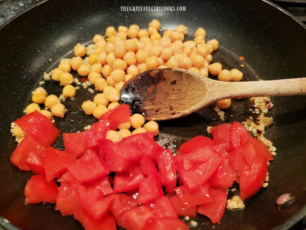 Chopped fresh tomatoes and drained chickpeas (garbanzo beans) are added to skillet.