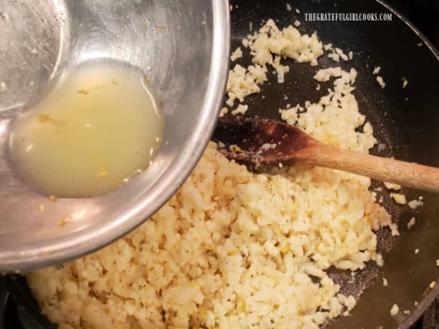 Fresh lemon juice is added to the seasoned riced cauliflower and stirred to combine.