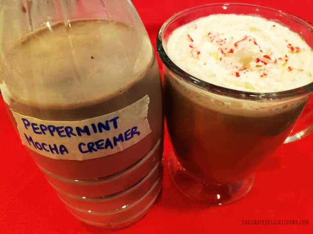 Whipped cream and peppermint top a cup of coffee with peppermint mocha creamer.