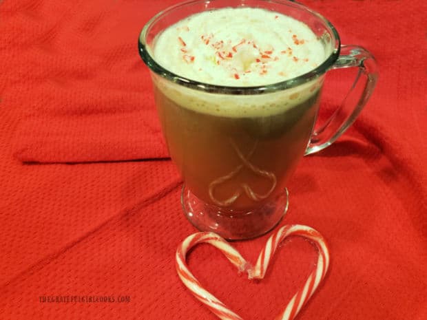 A mug of whipped cream topped coffee sweetened with peppermint mocha coffee creamer.