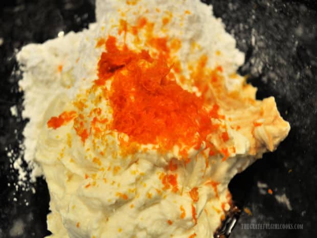 Powdered sugar, vanilla and orange zest is added to drained, blended ricotta cheese for cannoli filling.