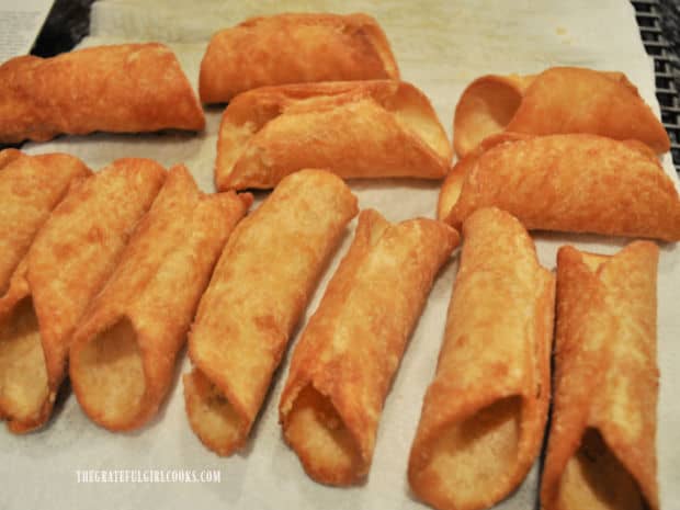 Some of the fried cannoli shells, cooling on paper towels before decorating and filling.