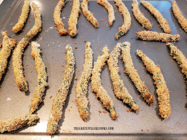 Coated green beans are baked in a single layer on a large baking sheet for 10 minutes.