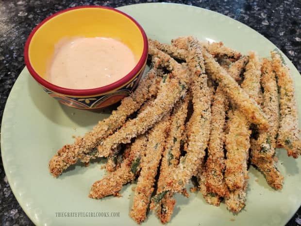 The crispy green bean fries are served hot, with a Ranch and Sriracha dipping sauce.