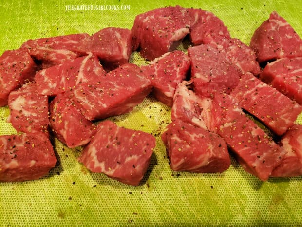 The steak bites are generously seasoned with salt and pepper before cooking.
