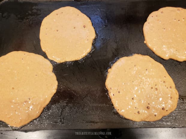 Gingerbread pancakes are cooked until bubbles form on surface, then pancakes are flipped.