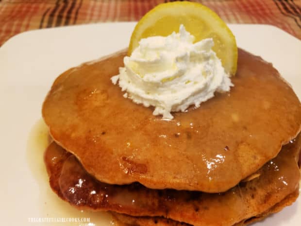 Gingerbread pancakes in lemon sauce are served with whipped cream and lemon wedge garnish.