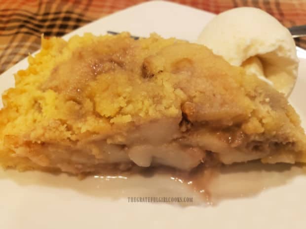 Slice of pear pecan shortbread tart served with ice cream on a white plate.