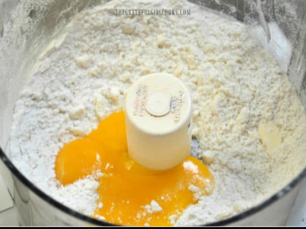 Egg yolks are combined with the crust mixture in food processor.