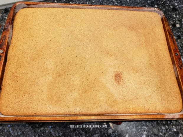 The pumpkin cake is removed from the oven after baking, and edges are loosened from pan.