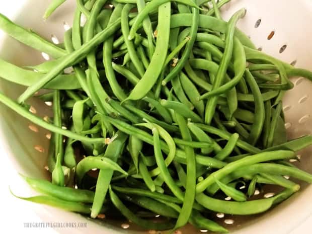 Fresh green beans are trimmed, then are ready to be seasoned.