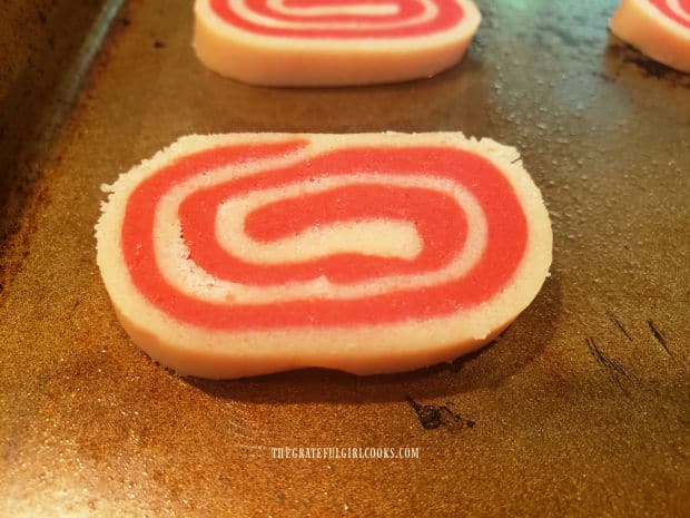 The peppermint pinwheel cookies are put on baking sheets 2" apart.