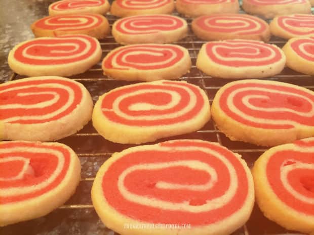 After baking, the peppermint pinwheel cookies cool on a wire rack.