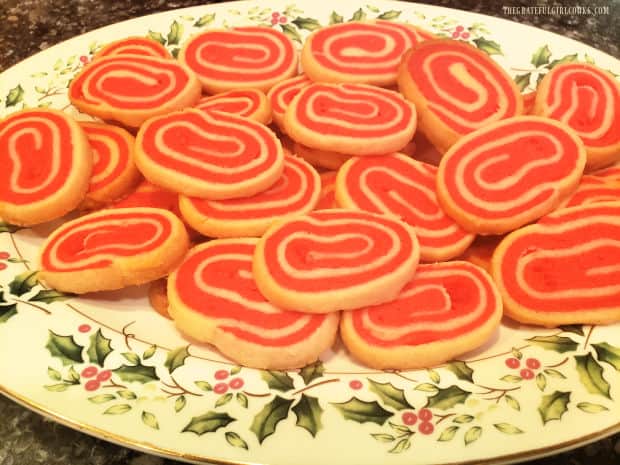 Peppermint pinwheel cookies are served on a festive and decorative Christmas platter.