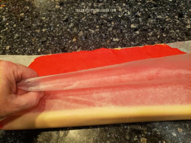 Dough for the peppermint pinwheel cookies is tightly rolled into a long log shape.