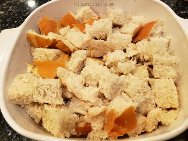 The French bread cubes are put into a greased baking dish.