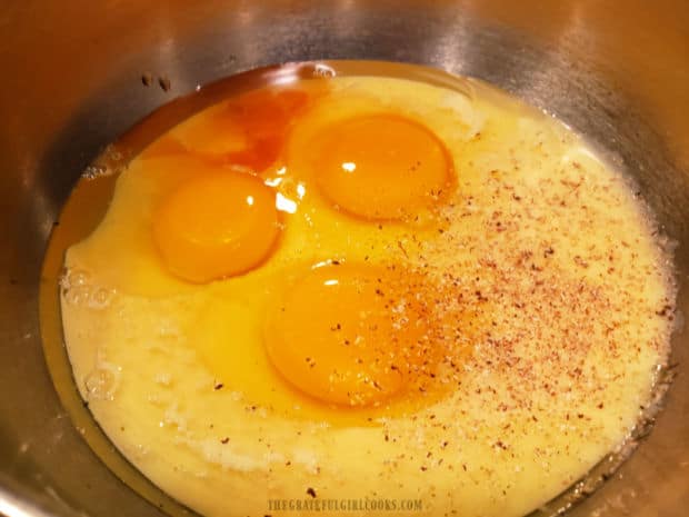Eggs, eggnog, vanilla and nutmeg are placed in a bowl and whisked to combine.