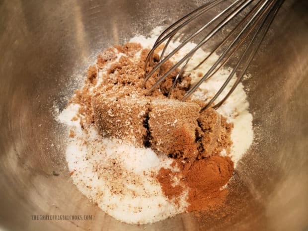 Flour, brown and white sugars and spices are whisked together in small bowl.
