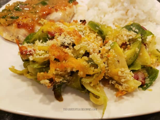 A serving of the brussel sprout casserole for two, served on a white plate.