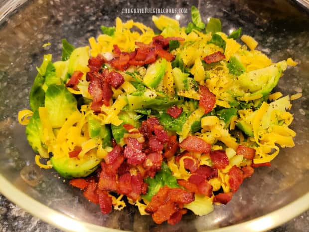 Sliced brussel sprouts, cheese, bacon, salt, pepper and half and half are mixed in bowl.