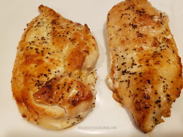 Pan-seared chicken cutlets rest on a white plate and kept warm while sauce cooks.
