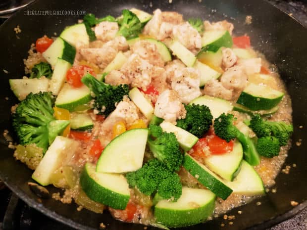 Quartered zucchini slices and chopped broccoli are added to the skillet.