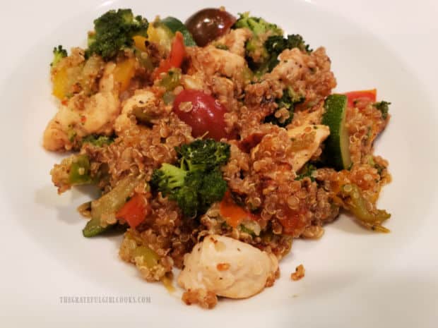 A white bowl with one serving of the chicken, quinoa and veggies, ready to be enjoyed.