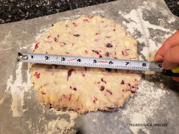 A measuring tape is used to measure dough into an 8" circle.