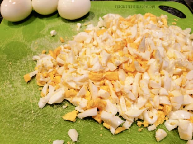 Eggs are hard boiled, peeled, then chopped into small pieces.