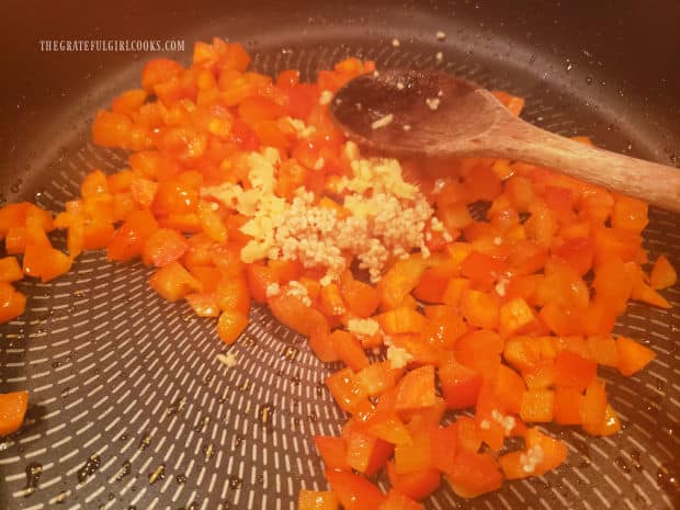 Minced garlic and fresh grated ginger are stirred into the veggies in the skillet.