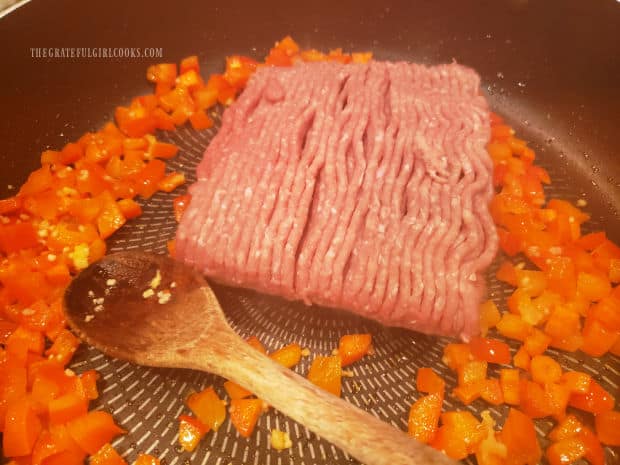 Ground turkey breast is added to veggies in skillet and is cooked.