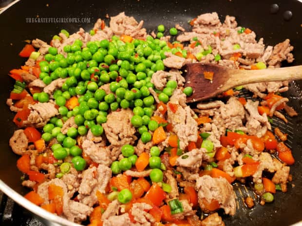 Peas and Asian sauce ingredients are added to the turkey veggie stir fry.