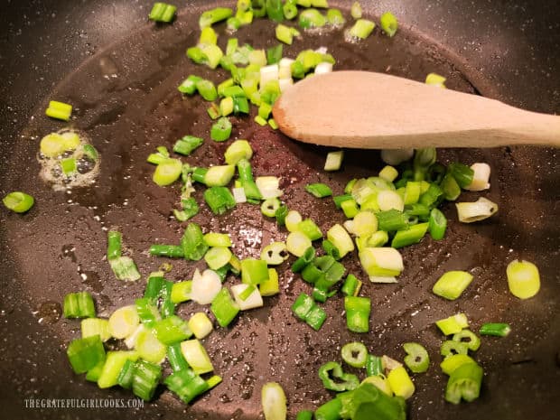 Chopped green onions are cooked in a lightly sprayed skillet on Medium-High heat.