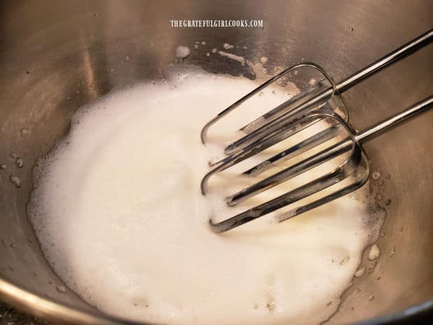 The egg whites are beaten until frothy, increased in volume, and soft peaks are formed.