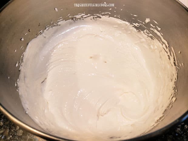Sugared egg whites are beaten with electric mixer until firm peaks can be formed.