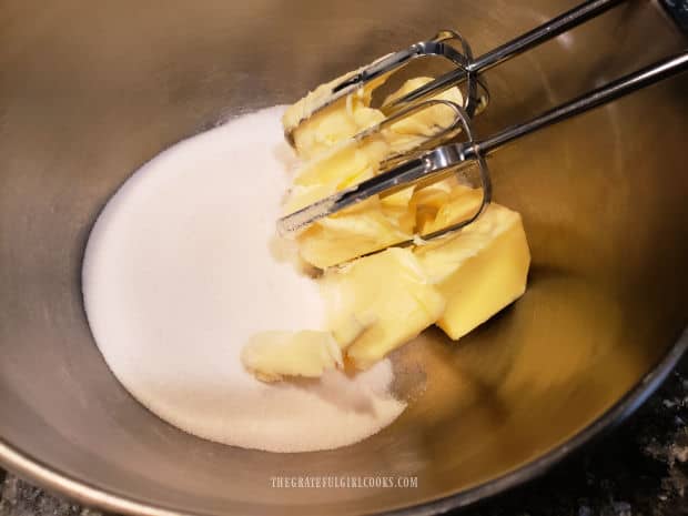 Granulated sugar and butter are creamed together in a large bowl, with an electric mixer.