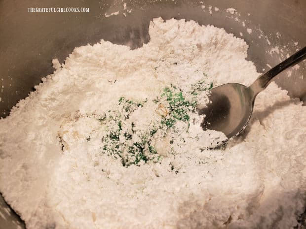 Mixing the ingredients for green icing to decorate the shamrock cookies.