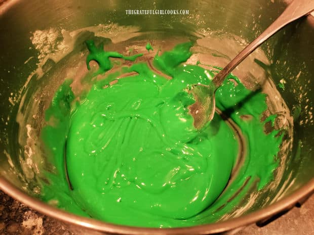 Green icing is mixed and is now ready to decorate the shamrock cookies.