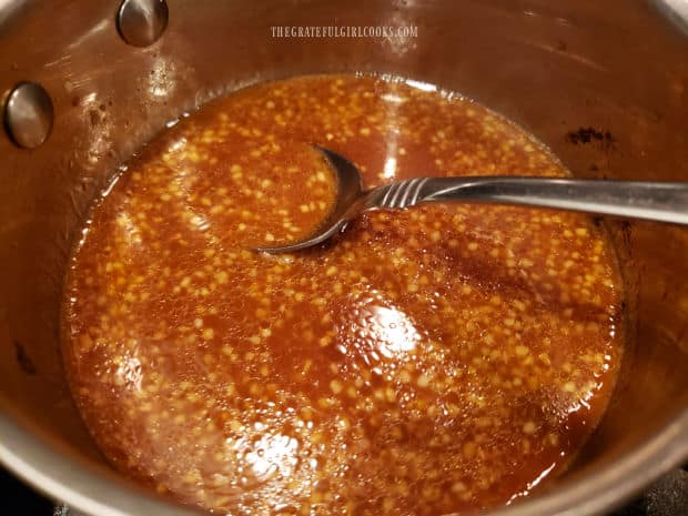 Ingredients for Asian sauce in saucepan, with a spoon.