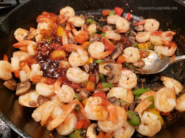 Cooked sauce and veggies are added back into skillet with the shrimp.