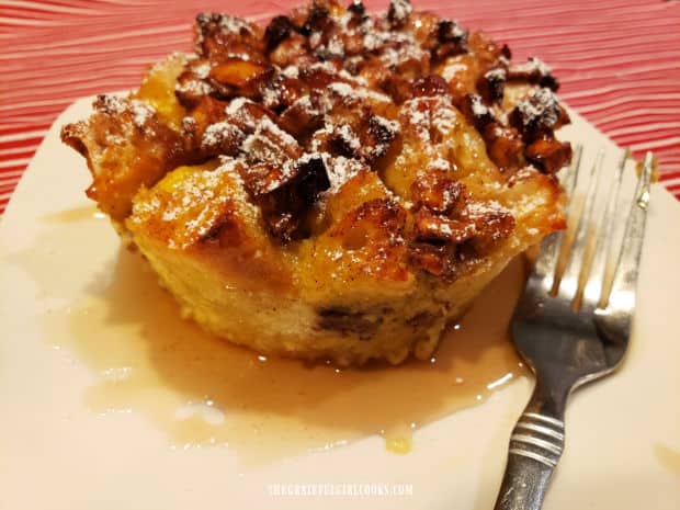 One of the Apple Pecan French Toast Cups, served with maple syrup, on a white plate, 
