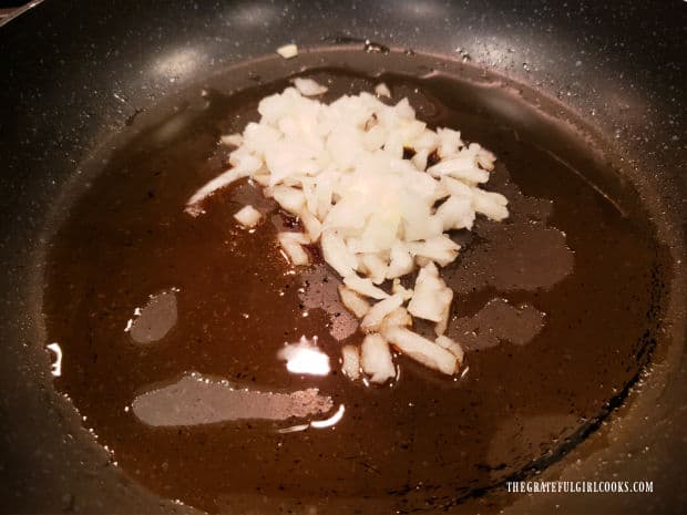 Chopped onions are cooked in sesame oil in a large skillet.