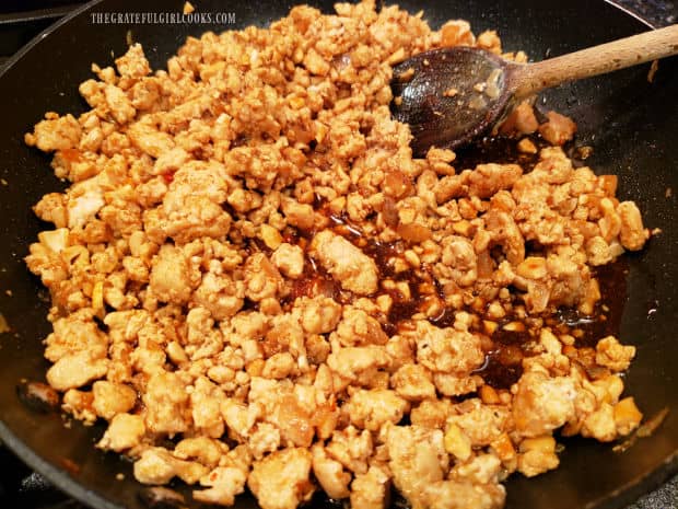 Asian sauce and chopped cashews are added to the skillet and stirred to combine.
