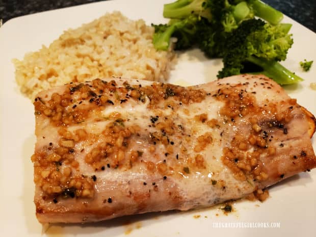 Easy baked mahi mahi, served with garlic butter sauce on top, brown rice and broccoli on the side.