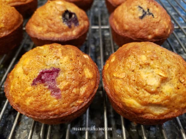 Muffins cool on wire rack after being transferred out of muffin tin.