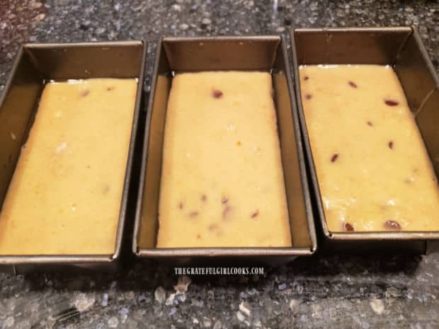 Batter is evenly divided between three greased mini loaf pans for baking.