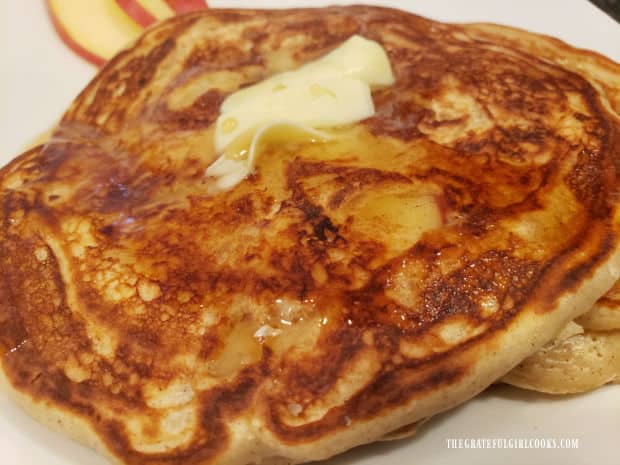 Butter and syrup are served on top of the chunky apple cinnamon pancakes.