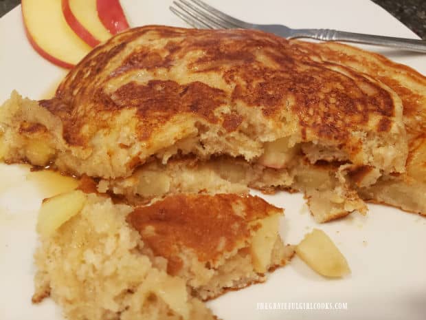 Pieces of apple can be seen throughout the cooked pancakes.
