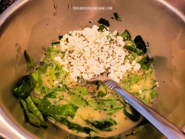 Lightly beaten eggs, milk, feta cheese and spinach are mixed in small bowl.