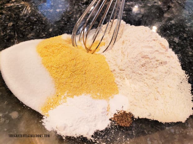 Dry ingredients for corn dog batter are whisked together until combined.